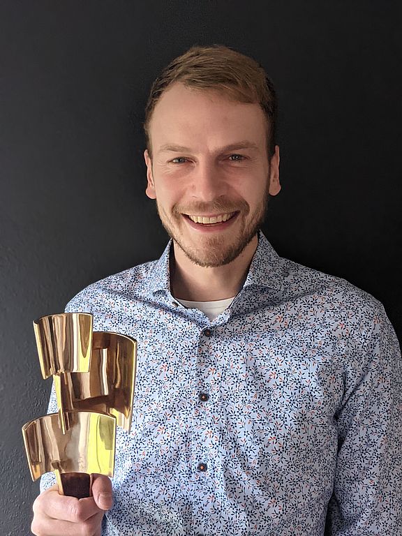 Johannes Wombacher mit Statue in der Hand