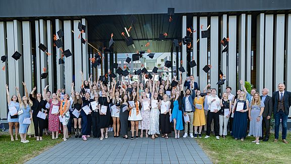 Studierende werfen Akademikerhüte in die Luft