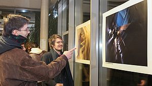 Zwei Studierende schauen sich die Fotos an.